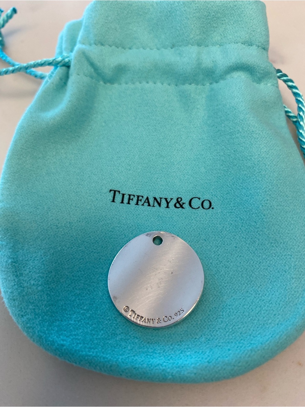 Tiffany & Co. Silver Engraved Round Tag “Notes” Pendant with Signature Pouch - Picture 2 of 3